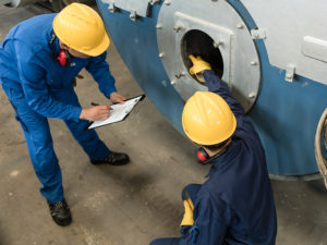 Mechanical contractors inspecting a boiler system | Brandt